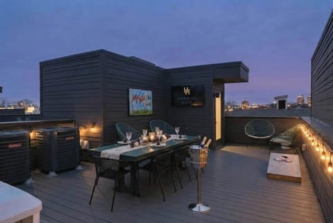Rooftop oasis with games, dining table and flat screen TV for a perfect entertaining afternoon or evening 