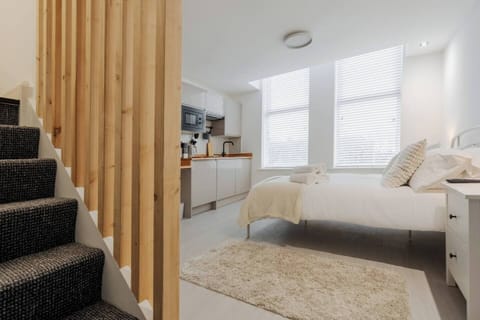 The open-plan living space includes a comfortable double bed and sofa bed, a Smart TV with Netflix, and a dedicated workspace. There is private mini fridge w/freezer, and washing machine, and bedside plugs with a direct USB port for easy charging. 