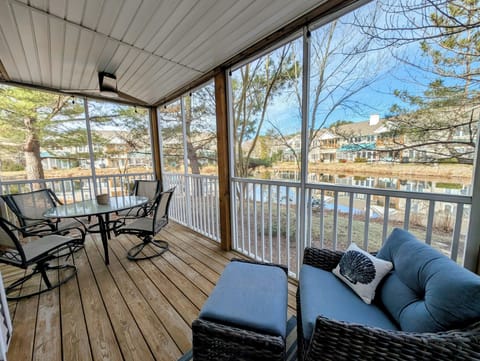 56152 Cypress Lake Circle - Waterfront Screened Porch - A stunning view from the oversized screened-in porch, which overlooks the peaceful community pond. Furnished with a glass-top dining table and plush wicker lounge seating with an ottoman, it serves as the ultimate spot for alfresco dining and relaxation.