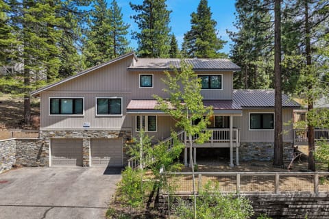 Beautiful mountain home nestled among towering pines with modern amenities and stone accents in a peaceful forest setting.