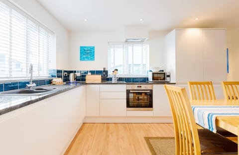 Fistral Palms 2, Newquay: The sleek kitchen is superbly equipped with  an electric oven and induction hob, fridge/freezer, microwave, and dishwasher