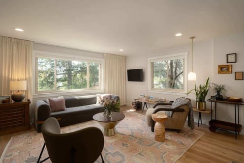 Unwind in this bright, thoughtfully styled living space filled with natural light, cozy seating, and a peaceful atmosphere perfect for relaxing evenings, movie nights, or quiet mornings with a book