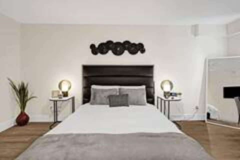 Queen bed with warm bedside lighting and decor