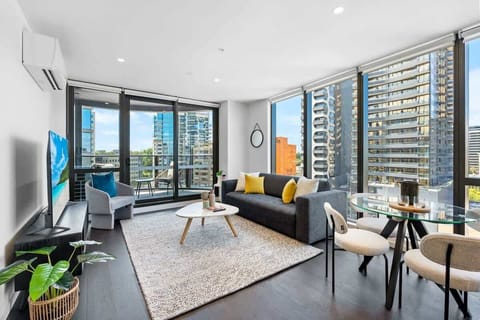 Experience the best of open-plan living—unwind on the plush, comfy couch while soaking in the vibrant city skyline right from your living space.