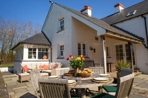 Patio area with table and six chairs laid for dinner