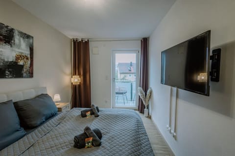 Das Schlafzimmer mit Doppelbett und Zugang zum Balkon