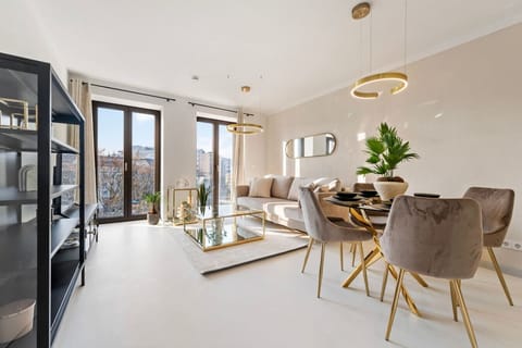 Living room with a very comfortable couch, smart TV, dining table, and city view.