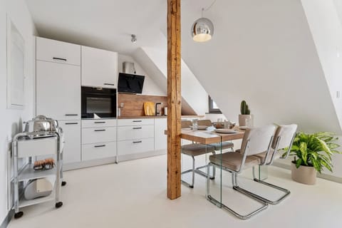 Die geräumige offene Küche und der Essbereich im unterem Teil der Maisonette Wohnung.