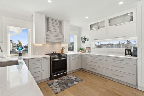 Open Luxury Fully Equipped Kitchen on the 2nd Floor with Beautiful White Cabinetry, Stainless Steel Appliances, and Quartz Countertops