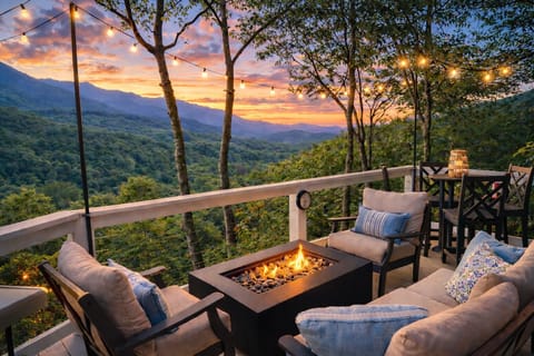 Cozy deck with fire pit and string lights looking out to sweeping mountain views