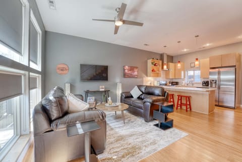 Bright living area with plush leather sofas, smart TV, and floor‑to‑ceiling windows that fill the space with natural light.