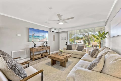 Relax in this modern living room with ample seating and natural light from large windows.