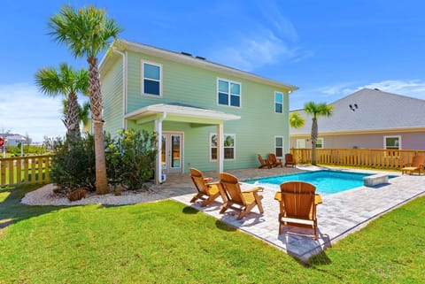 Charming coastal home featuring your private pool oasis with Adirondack chairs, surrounded by tropical palms and manicured lawn.