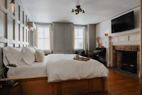 The Austen Room offers a perfect balance of warmth and sophistication. Featuring a luxurious king bed, a decorative fireplace, and elegant wood accents, this spacious retreat is designed for ultimate relaxation. Please note: the fireplace is for decoratio