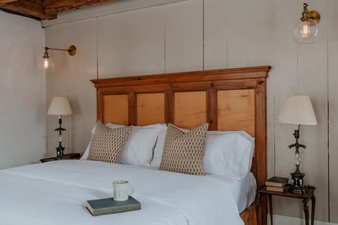 The Hemingway Room’s king-size bed offers a luxurious retreat, framed by warm wood tones and soft lighting. A perfect space to unwind and recharge in rustic elegance.