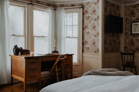 Charming Workspace for Inspiration – This elegant writing corner, complete with antique books and a flickering candle, provides the perfect setting for creativity, reflection, or catching up on work.