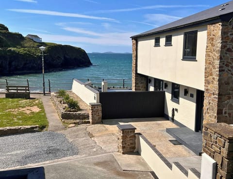 Seafront house exterior with terrace walls and path leading towards the water
