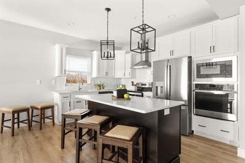 - Sleek black island with seating for three perfect for casual meals or evening drinks
- Fully stocked kitchen with stainless steel appliances and plenty of prep space
- Natural light, open layout, and modern lighting add a fresh vibe