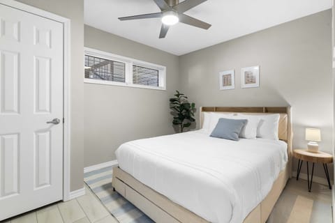 A plush queen bed awaits in the first bedroom retreat