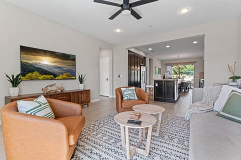 Inviting living room w/ cozy seating, wall-mounted TV & natural light for relaxed lounging