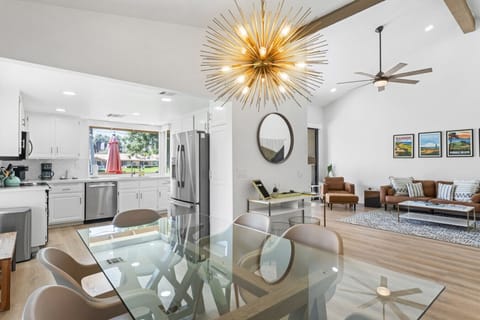 Bright open kitchen & dining area w/ statement chandelier, sleek finishes & a seamless flow for gathering