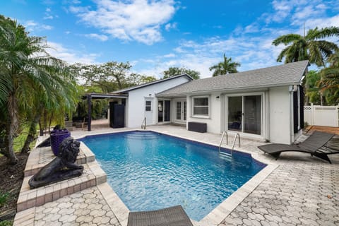 This lush, tropical sanctuary features a large, sparkling pool with cascading waterfalls, creating a tranquil, resort-like ambiance.