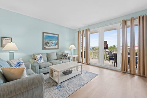 Relax in this coastal-inspired living room with balcony access and natural light.