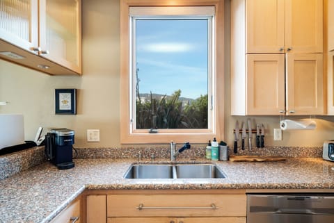 Ocean view fully equipped kitchen with breakfast bar, gas range, dishwasher, full fridge and microwave.