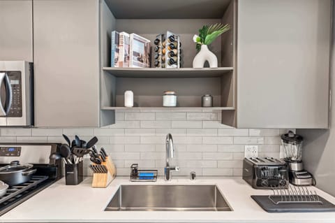 Designer kitchen with modern cabinetry, elegant tile backsplash, and all essentials for inspired cooking.