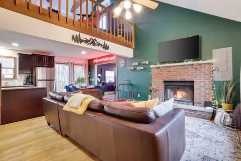 View of living room with kitchen, dining area and loft in back.