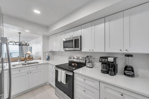 Sleek kitchen w/ stainless steel appliances and crisp white cabinetry throughout.