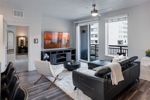 Beautifully designed living room. 65` TV, leather sofa and amazing views of mountains and city skyline.