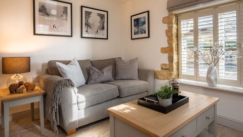 A comfortable sofa invites you to settle in by the crackling woodburner.