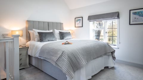 The super king-sized bed, crisp and generous, is the perfect cosy spot to unwind.