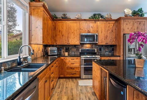 Fully equipped kitchen featuring modern appliances, ample counter space
