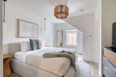 Sleeping area with queen bed and TV dresser.