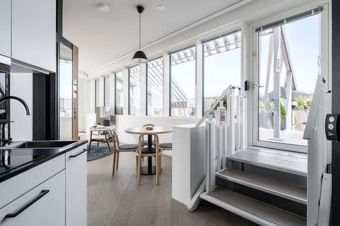 Modern, fully equipped kitchenette and hallway with sleek black and white finishes.