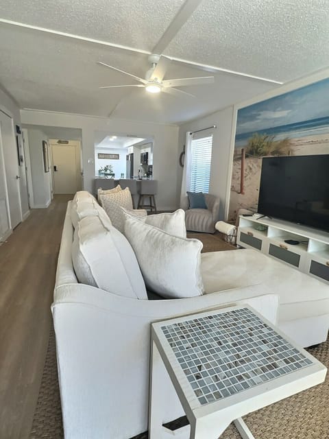 Large couch and two chairs for a comfortable seating arrangement.  Plus, a 65-inch LG TV.