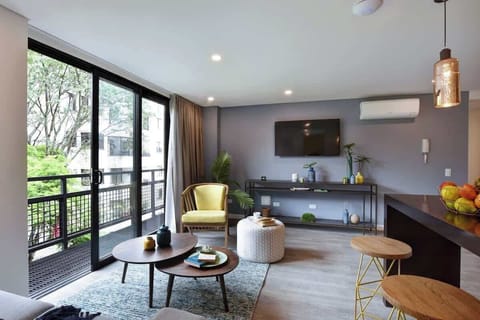 Open living room connecting to balcony and kitchen. The space comes with SmarTV, A/C and curtains. 