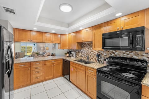 Fully equipped kitchen with ample cabinetry and appliances for meal prep.