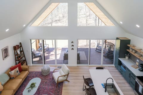 Bask in natural light and pond views from this stylish open-concept living area—featuring a fully equipped kitchen, cozy seating, and direct access to the outdoor deck.