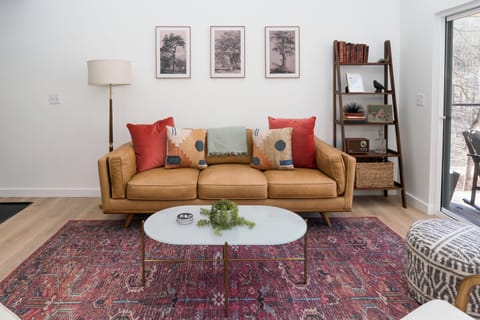 Main floor living area at Austen — leather sofa, vaulted ceilings, open to the kitchen and dining area