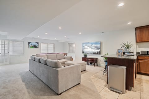 The downstairs family room has a classic pool table, large sectional, 2nd full kitchen and large smart TV