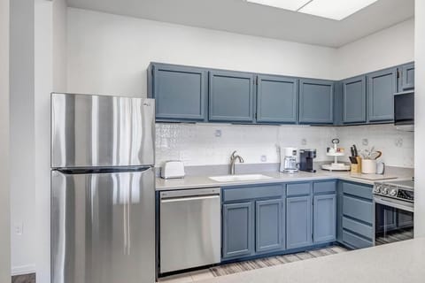 - Stylish kitchen with deep blue cabinetry and all stainless steel appliances included
- Tiled backsplash and skylight bring brightness to your meal prep and morning coffee
- Fully equipped with cookware, utensils, and essentials for effortless stays