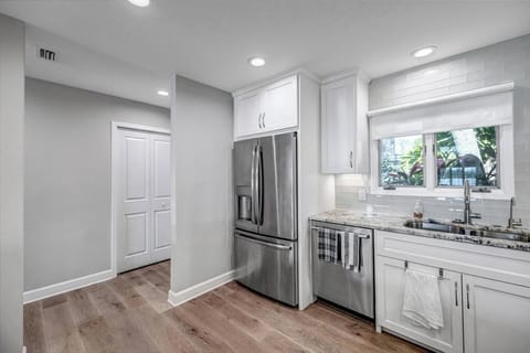 - Sleek kitchen entry with plenty of space and a view into the bright hallway nearby
- Built in stainless appliances and farmhouse style sink by the window add charm
- Whether you're unpacking groceries or prepping lunch, it's effortless here