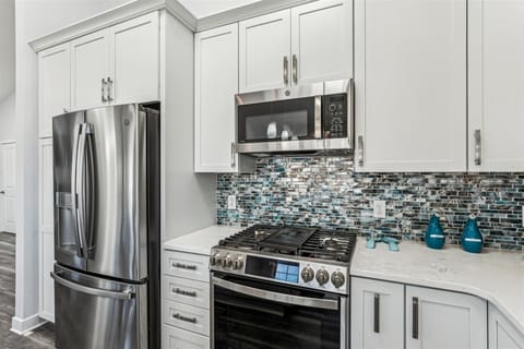 Your modern kitchen awaits with sleek appliances and stunning mosaic backsplash, perfect for creating memorable meals during your stay.