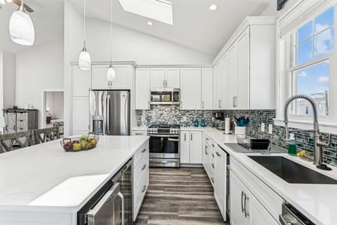 Your gourmet kitchen awaits with pristine white cabinets, quartz countertops, and professional appliances ready for memorable meal preparations.