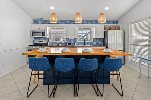 A dining table for four with a view of the kitchen creates a cozy and inviting atmosphere. It’s perfect for casual meals, allowing guests to enjoy the conversation and the action happening in the kitchen, making the space feel open and connected. Whether 