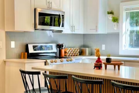 Modern and fully equipped kitchen featuring sleek white cabinetry.