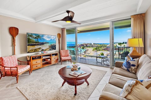 Bright and inviting living space with coastal-inspired décor, comfortable seating, and large sliding doors that open to a private lanai showcasing beautiful ocean views—perfect for relaxing and enjoying the island breeze.